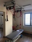 Wnętrze dziennego domu pomocy. Gabinet rehabilitacji ruchowej. Stanowisko rehabilitacyjne składające się ze stołu rehabilitacyjnego i wyciągu sufitowego